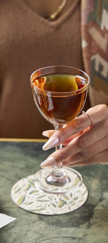 A woman holding a glass of whiskey