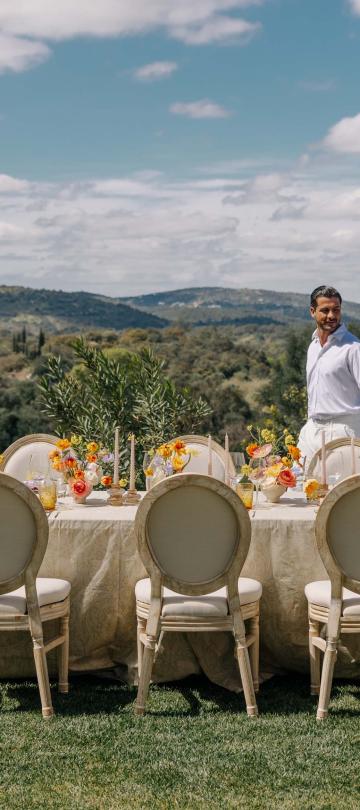 couple walking along a table set for a wedding outside