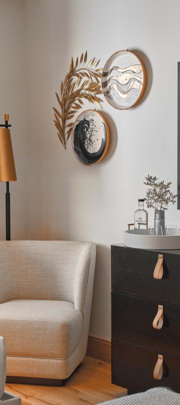 Bedroom with chair and dresser with a tv mounted on the wall