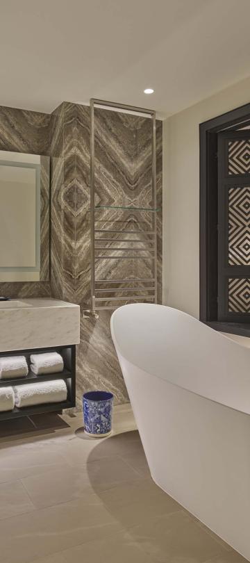 Bathroom with large vanity, bathtub, and window to room