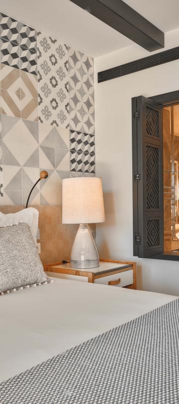 Bedroom with king bed and nightside table with a window to the bathroom open