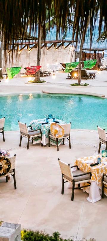 Dinner tables set up by the pool