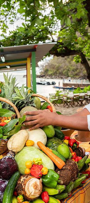 A woman staking fruit and vegetables at a stand