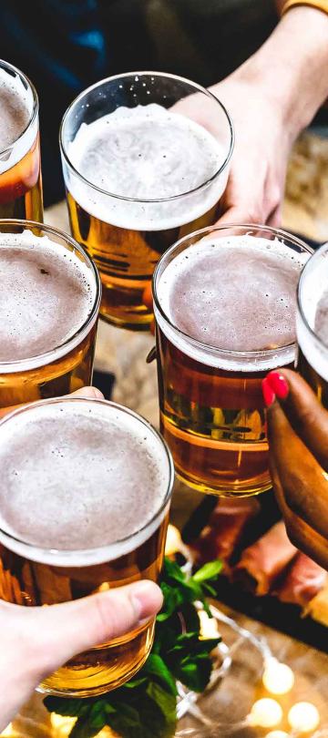 A group of friends tapping their beer glasses together