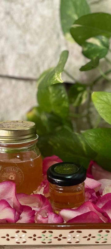 Jars of honey on a tray of flower petals
