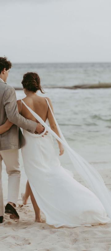 Bride and groom walking on the beach