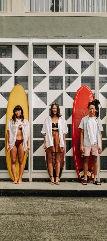 A group of friends standing in front of their surf boards