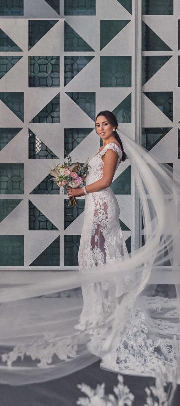 Bride in a beautiful gown with her veil flying in the wind