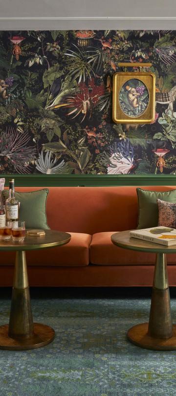 Green room with gold and orange accents including two chairs and a couch