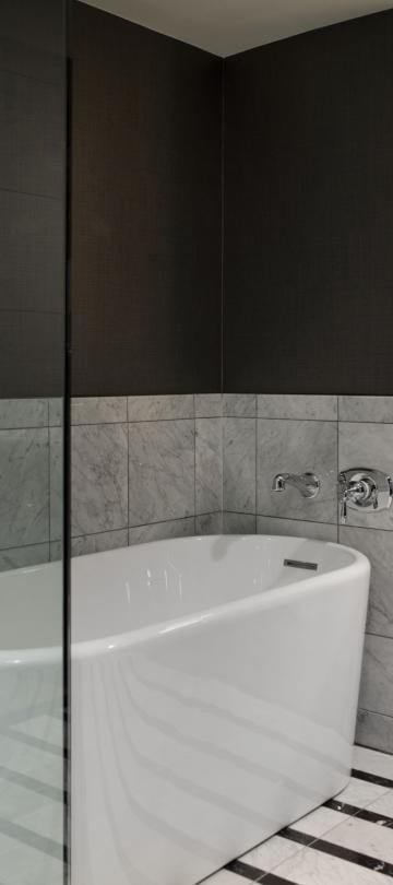 Bathroom with shower and tub separated by a glass wall