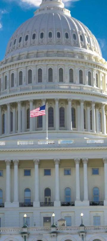 A front view of the White House on Capitol Hill with the American flag flying at full mast.