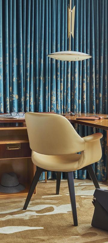 A boomerang desk in a Viceroy hotel room, next to a window looking out on the Chicago skyline