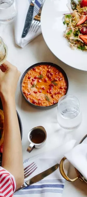 A woman enjoys a table full of food and wine