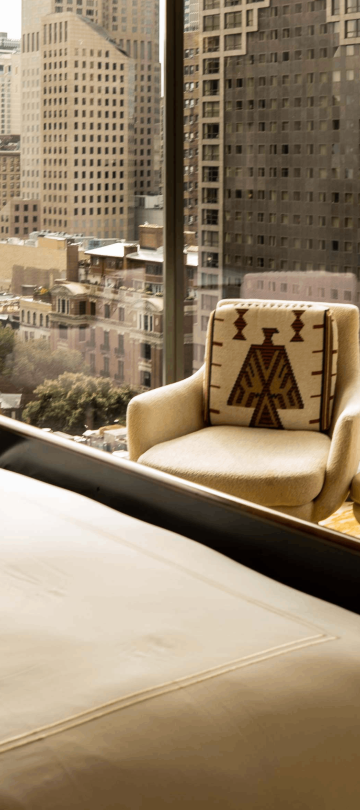 A chair against the floor to ceiling windows in a room at Viceroy Chicago