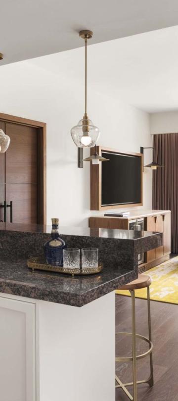 A large kitchen with an L-shape counter, living space, and a balcony in a suite at Viceroy Kopaonik Serbia