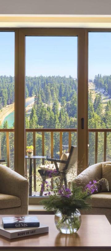 The living space with a TV, couch, and two chairs in a suite at Viceroy Kopaonik Serbia