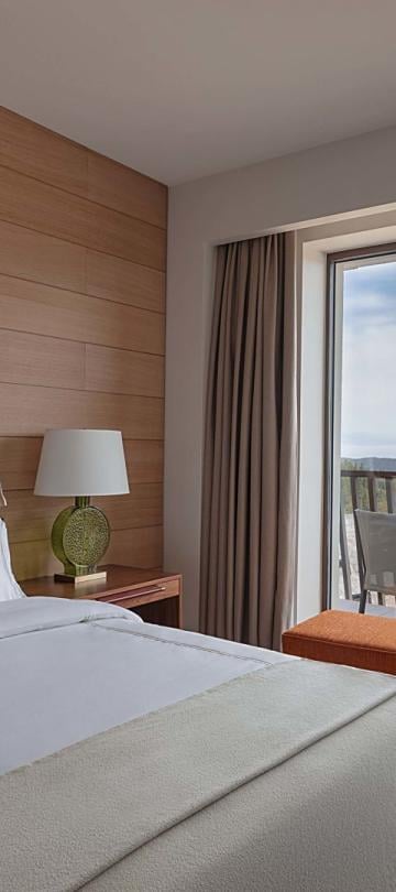A king bed and a balcony in a suite at Viceroy Kopaonik Serbia