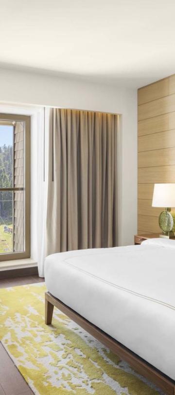King room with a king bed, couch, dresser and tv at Viceroy Kopaonik Serbia