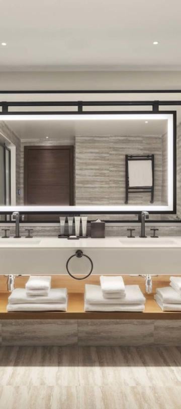 A washroom with a large double sink vanity and a soaker tub in a penthouse suite at Viceroy Kopaonik Serbia