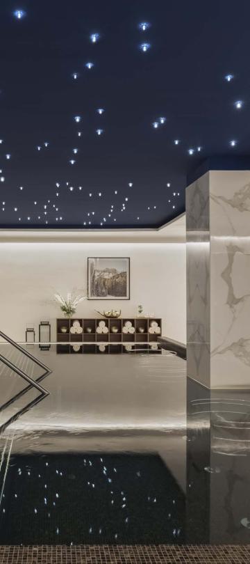 The spa at Viceroy Kopaonik Serbia, with a wading pool and recliners under a ceiling painted like a starry sky