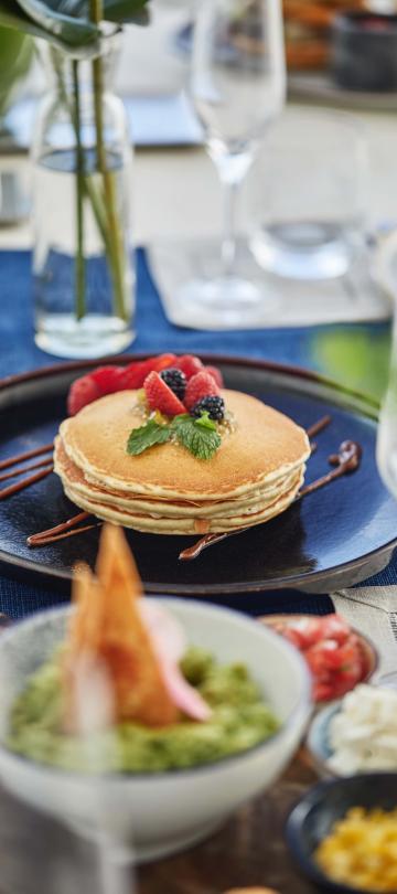 A plate of pancakes and breakfast items from Casero