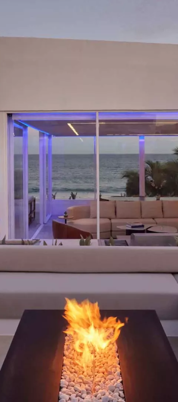 Exterior of a villas with a view of the ocean and a patio fireplace