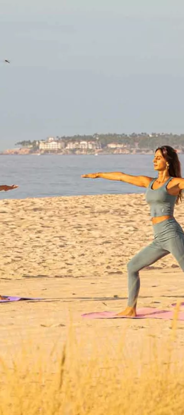 3 women doing yoga on the beach at Viceroy Los Cabos