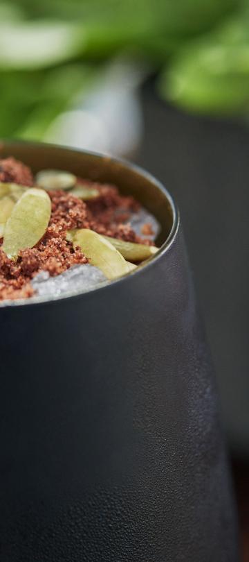 A close up of a drink with garnishes from Otro Bar