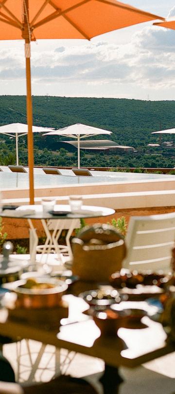 Two people sitting on a patio with some food and drinks at Ombria Algarve