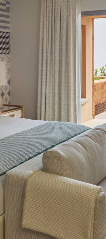 A king bed ina room with a couch, dresser, and a patio at Ombria Algarve
