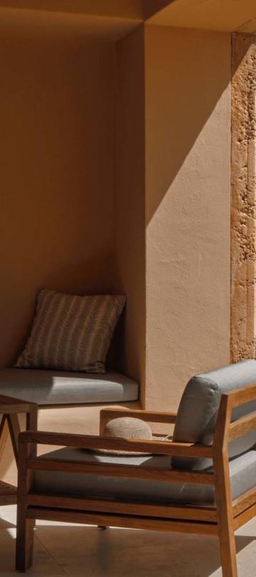 A covered terrace with bench seating and a chair at Viceroy Ombria Algarve