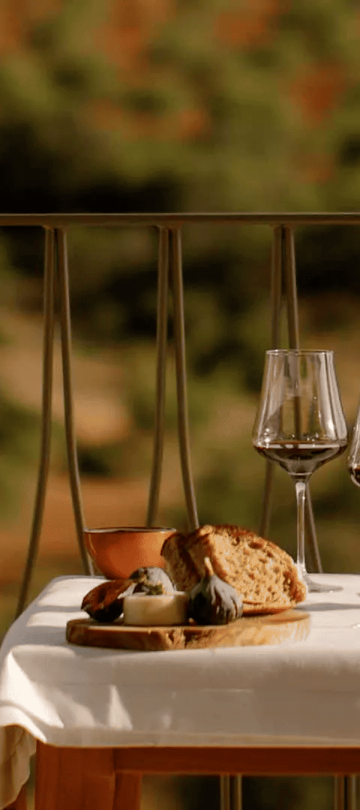 A table with a wine bottle , cheese and bread at Ombria Algarve