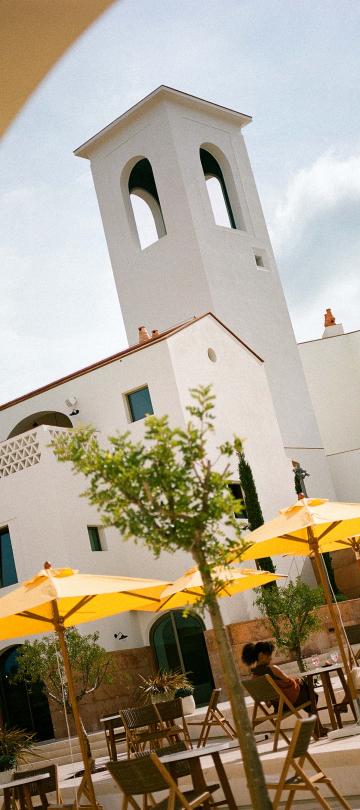 Patio tables shaded by yellow umbrellas at Cafe Central