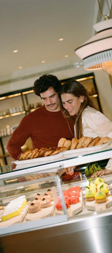 A couple looks at the assortment of pastries at Cafe Central