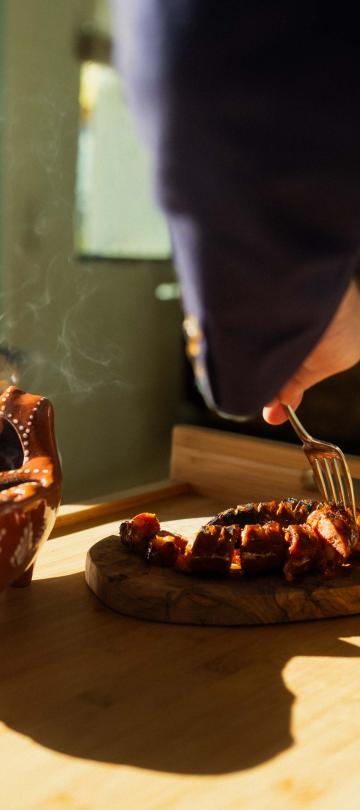 A server preparing a dish for a guest