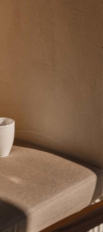 A coffee mug and newspaper resting on a reading nook on an outdoor space of a residence at Viceroy Ombris Algarve