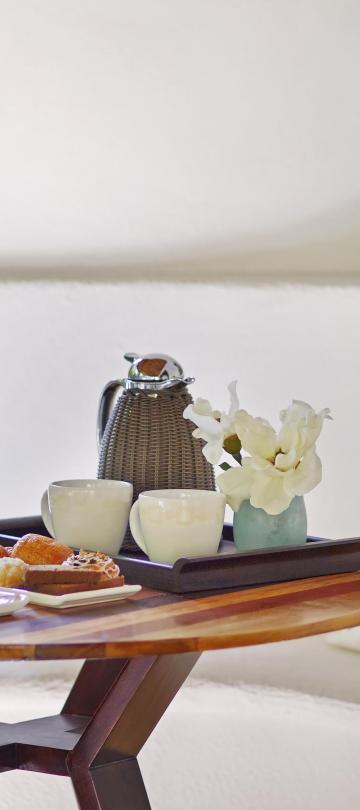 A small round table with coffee and breakfast food items at Viceroy Riviera Maya
