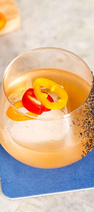 A cocktail garnished with banana peppers