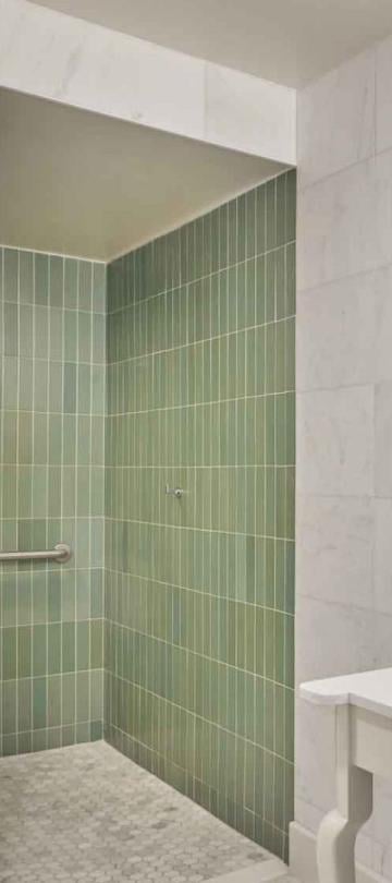 A vanity and green tiles shower in a suite at Viceroy Santa Monica