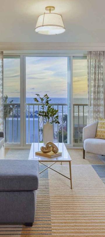 A living room with a couch, credenza, and TV in a Junior Suite at Viceroy Santa Monica