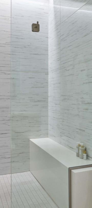 A marble bathroom with a bathrobe on a hanger