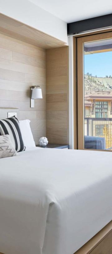 A large King bed looking out on a mountain village