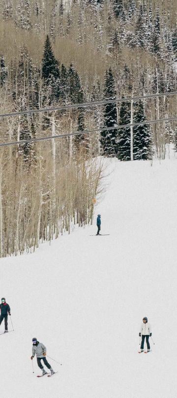 Skiers descend Snowmass mountain