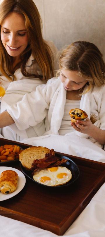 A mother and her two kids having breakfast in bed at Viceroy Snowmass