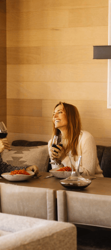 A couple laughing, eating and drinking wine at Viceroy Snowmass