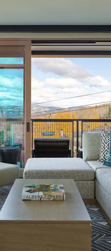 A room with an L-shaped couch and a fireplace at Viceroy Snowmass