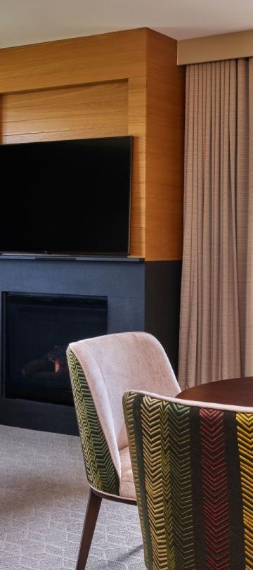 The dining and living room with a fireplace in a pinnacle two bedroom residence at Viceroy Snowmass