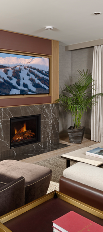 Large living room with a fireplace and two balconies in a Pinnacle Three Bedroom Penthouse at Viceroy Snowmass