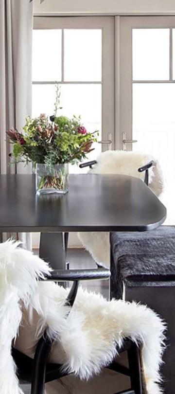 A dining table next the the living room in a Pinnacle Two Bedroom Premium Residence at Viceroy Snowmass
