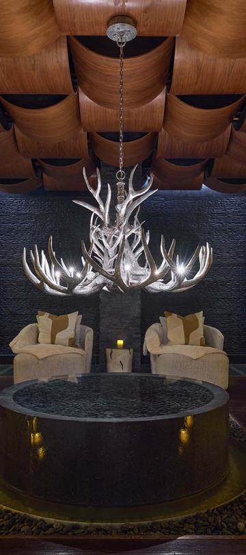 A Viceroy Snowmass spa waiting room, featuring cozy chairs and plush curtains, lit by candle